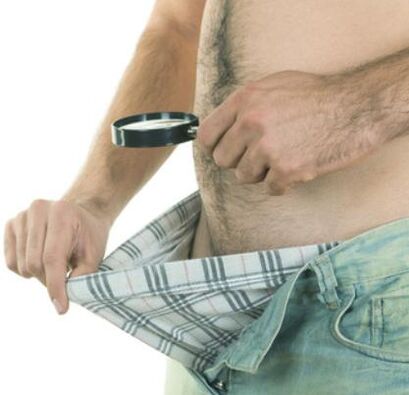 man examines his penis and wants to enlarge it